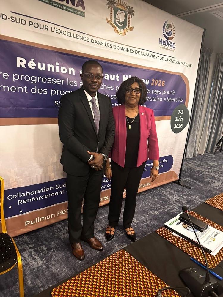 Two delegates stand together in front of the meeting backdrop, which reads “Réunion de Haut Niveau 2026”, “1–2 Juin, 2026” and “Pullman Hotel”.